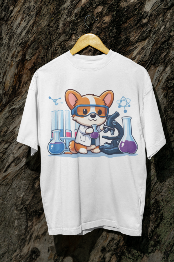 Oversized white t-shirt featuring a cartoon corgi scientist in lab goggles and lab equipment, hung on a tree log.