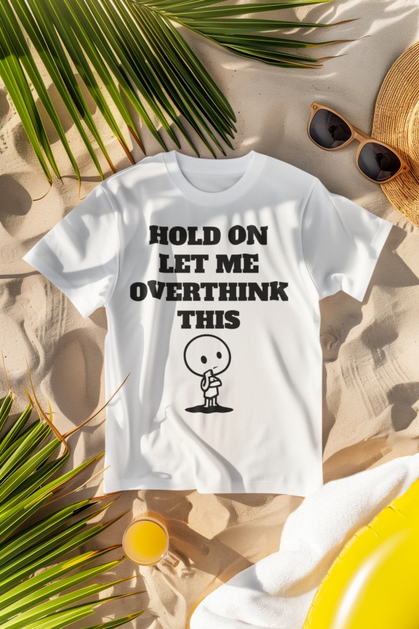 A white T-shirt with the text "Hold On Let Me Overthink This" displayed on the sand with sunglasses, palm leaves, and a juice for a summer beach vibe.